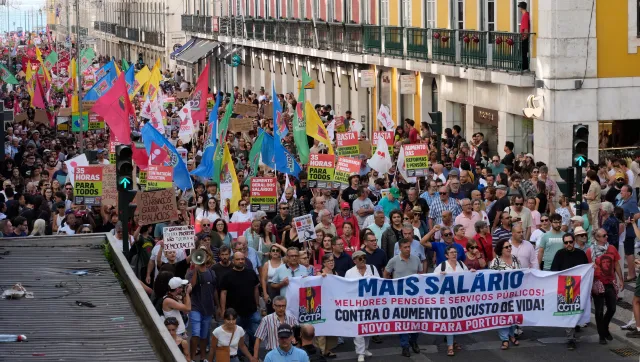 Participants hold signs and flags as thousands march at CGTP-IN decentralized national demonstration to demand higher wages, better pensions, and improved public services from Cais do Sodré to Rossio on October 17 in Lisbon.