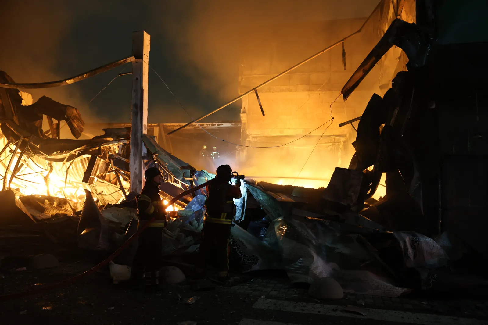 Ukrainian firefighters work at the site of a shopping center damaged in a missile strike on Kyiv on Thursday.