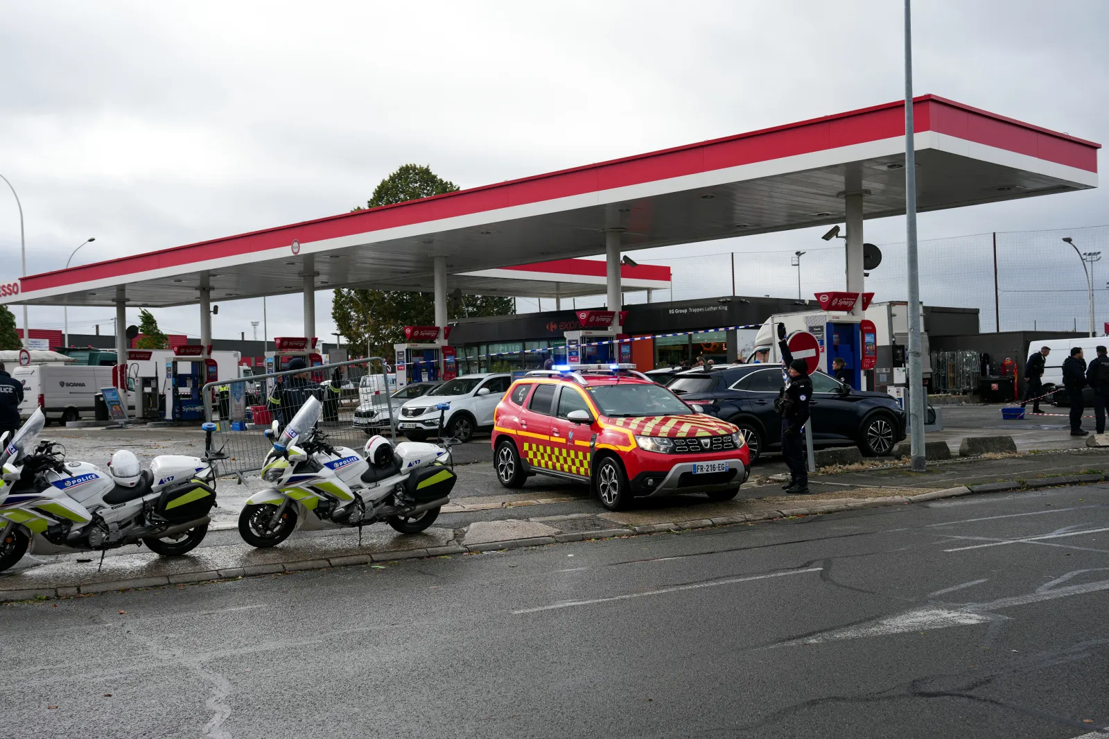 Police officers intervene on a site of a petrol station where a man opened fire from his car, according to police sources, in Trappes, Paris' suburb on October 23, 2026.