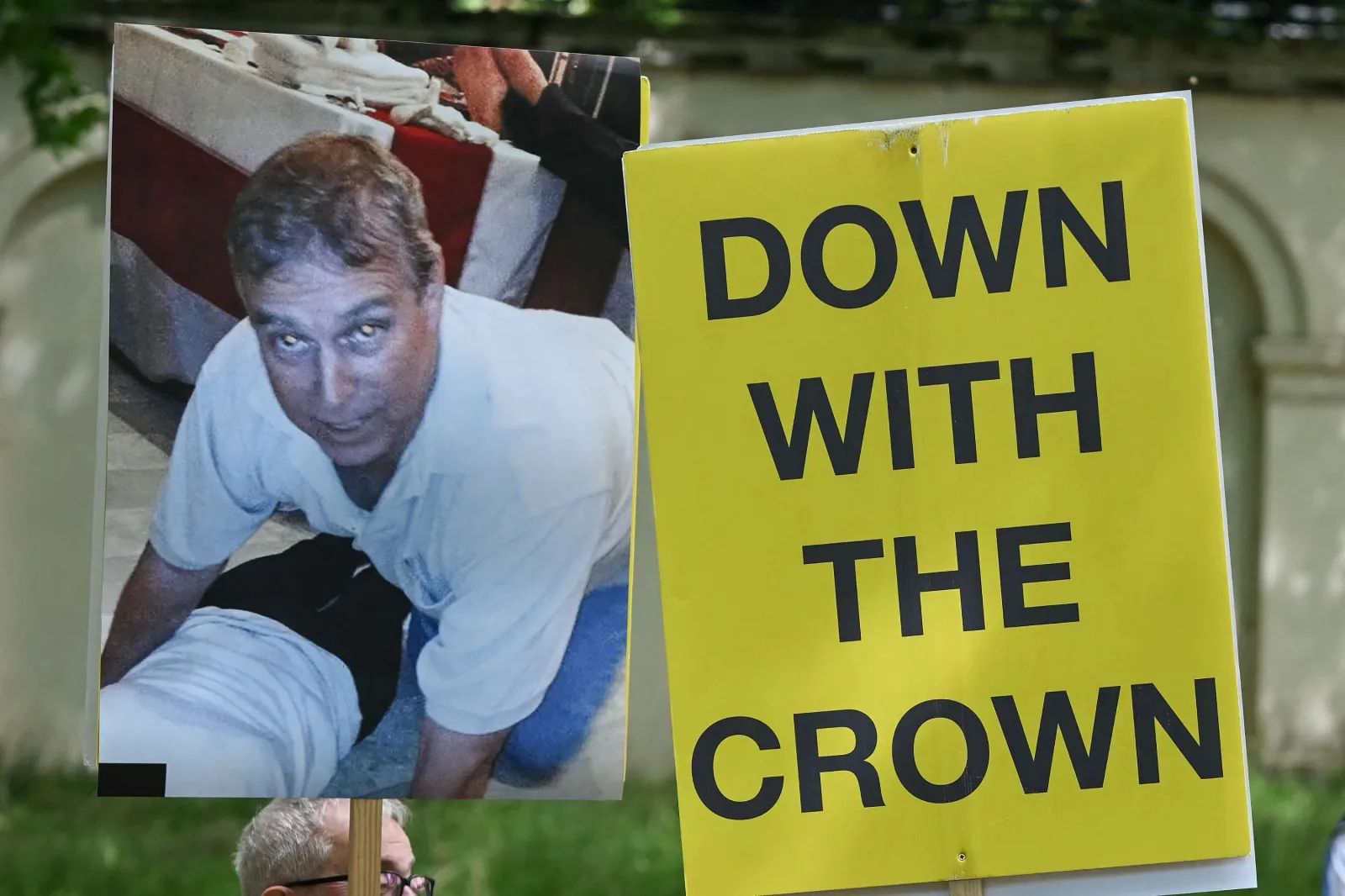 Protesters hold placards showing a photo of Andrew Mountbatten-Windsor first published in the Epstein Files during the King's Birthday Parade "Trooping the Colour," in London, on June 13, 2026.