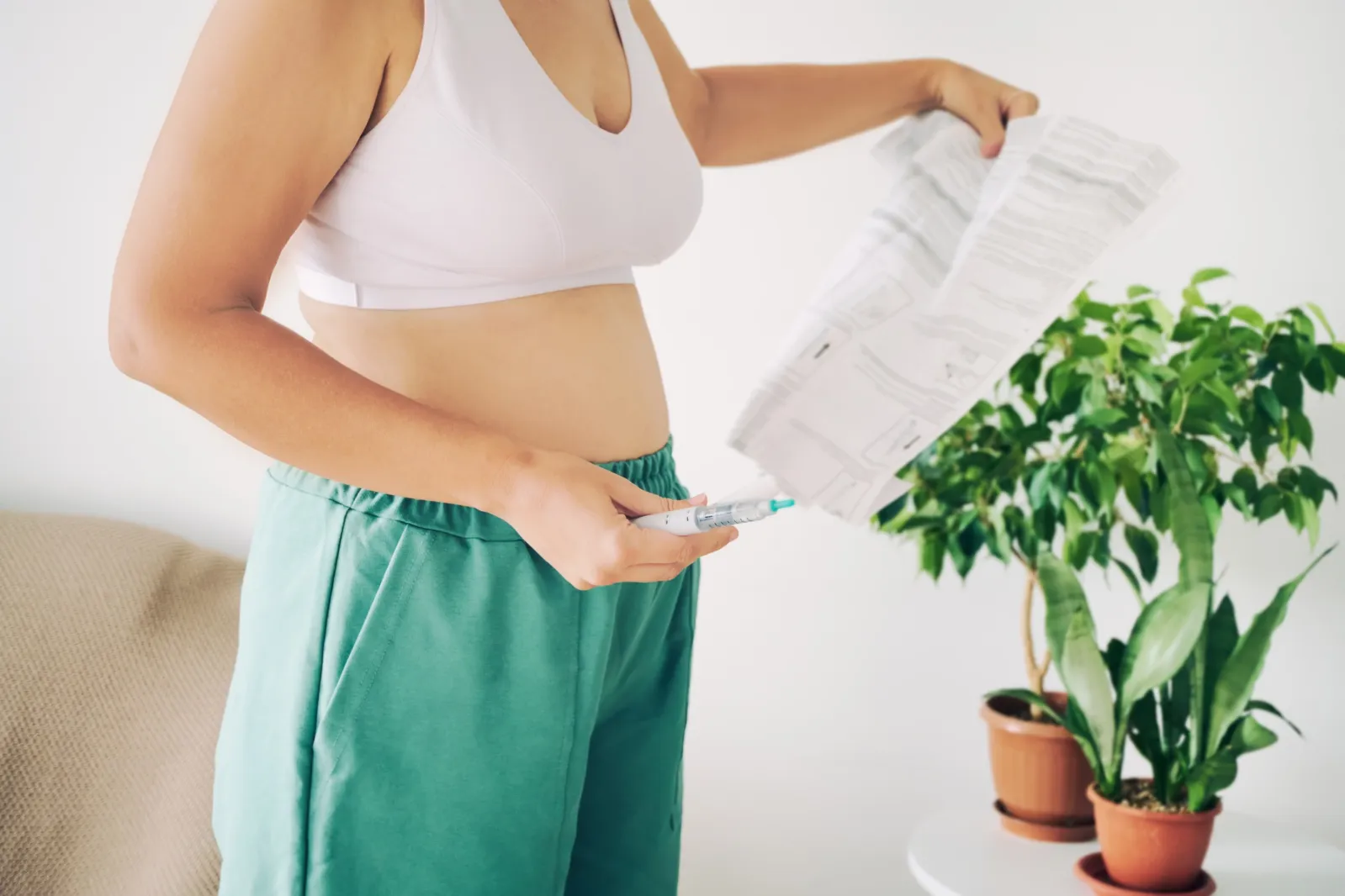 A woman reading instructions while preparing a GLP-1 injection for her health and weight loss.